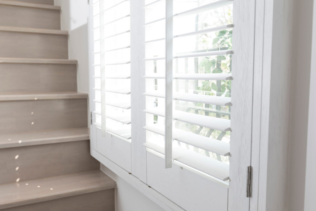 Closeup view of window with horizontal blinds. White Roller Blinds or Louver curtains at the glass window